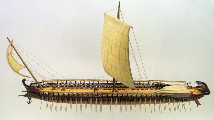 Miniaturnachbau einer Trireme, ein Bootstyp, der von den antiken Zivilisationen des Mittelmeers verwendet wurde. | Bildquelle: dpa/Matthias Kabel (PD) Miniaturnachbau einer Trireme, ein Bootstyp, der von den antiken Zivilisationen des Mittelmeers verwendet wurde.