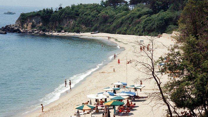 Blick auf einen den Strand von Druschba am Schwarzen Meer mit sonnenhungrigen Urlaubern.
