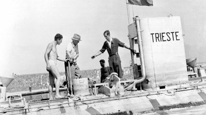 Die Meeresforscher Auguste Piccard (Mitte, mit Hut) und Jacques Piccard (rechts) an Bord ihres Tauchboots "Trieste" 1953
