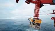Tiefseeroboter ROV KIEL 6000 wird mit einem Kran ins Meer gelassen.
