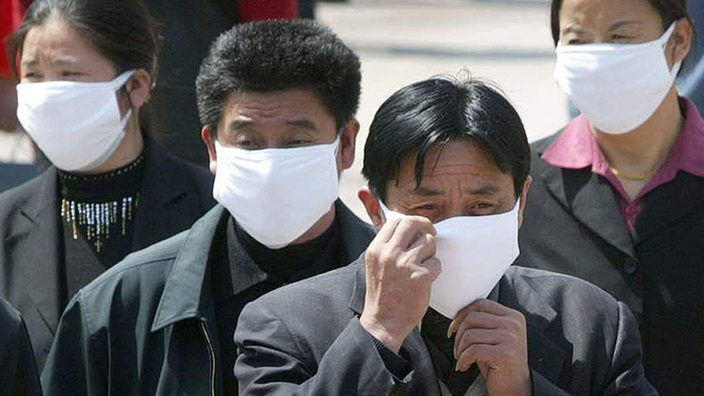 Mehrere Chinesen mit Mundschutz.