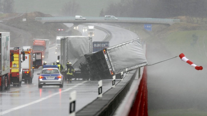 Auf einer Autobahnbrücke hat der starke Wind einen Laster umgeworfen. | Bildquelle: dpa/Michael Reichel Auf einer Autobahnbrücke hat der starke Wind einen Laster umgeworfen.