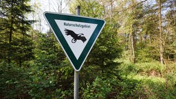 Schild mit der Aufschrift "Naturschutzgebiet" in einem Wald bei Hamminkeln-Dingden.