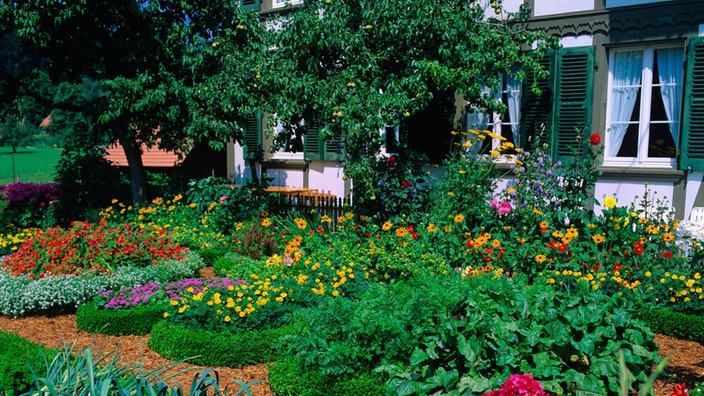 Üppiger Blumenschmuck vor einem bayerischen Landhaus.