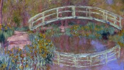 Das Ölgemälde zeigt einen Garten mit einer Brücke, die sich in einem Teich spiegelt. Blau- und Rottöne dominieren das Bild.