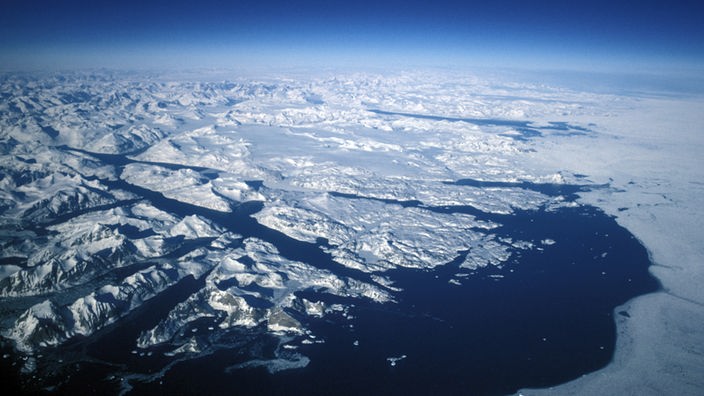 Luftaufnahme über dem Südosten von Grönland mit Gletschern, Packeis und Fjorden.