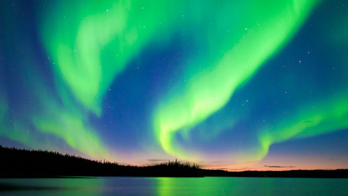 Weiß-grüne Polarlichter leuchten am kanadischen Nachthimmel.