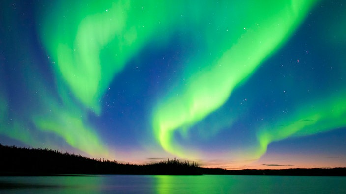 Weiß-grüne Polarlichter leuchten am kanadischen Nachthimmel. | Bildquelle: dpa Picture-Alliance / Wayne Lyn Weiß-grüne Polarlichter leuchten am kanadischen Nachthimmel.