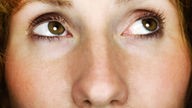 Nahaufnahme: die braunen Augen einer blicken nach rechts-oben.