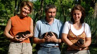 Nebeneinander stehen die drei Gründer des "WSC" mit jeweils einem Welpen auf dem Arm: Dr. Friederike Range, Kurt Kotrschal und Zsófia Virányi