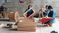 Drei südamerikanische Frauen beim Zusammenbau von Teakholzmöbeln in einem kleinen Handwerksbetrieb.
