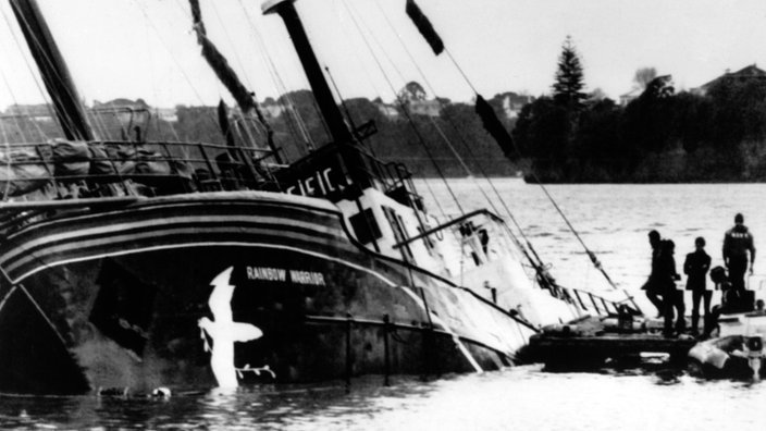 Schwarzweiß-Foto eines Schiffes, das auf der Seite im Wasser liegt und zu sinken droht | Bildquelle: dpa Schwarzweiß-Foto eines Schiffes, das auf der Seite im Wasser liegt und zu sinken droht