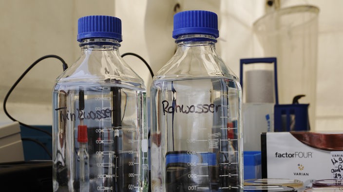 Plastikflaschen mit Rohwasser und Trinkwasser auf einem Labortisch
