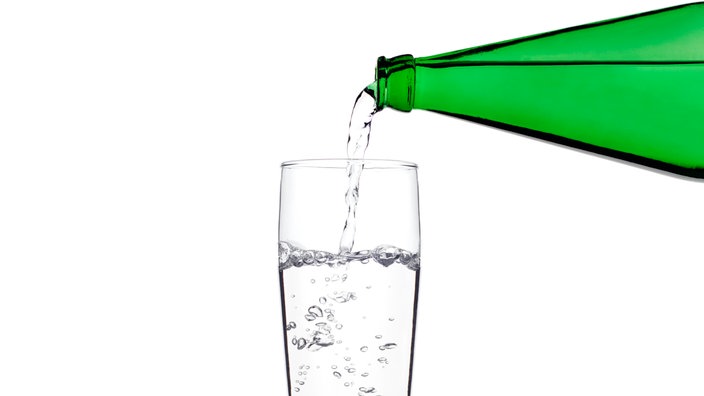 Eine Flasche und ein Glas mit Wasser.
