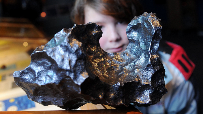 Volkssternwarte München: Ein Junge schaut auf einen Meteoriten