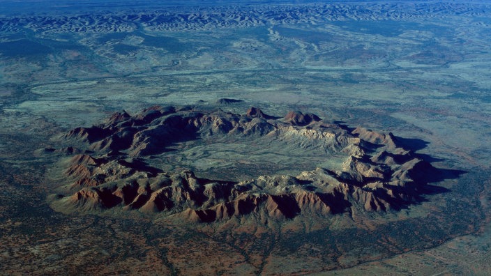 Der Impaktkrater aufgrund eines Meteoriteneinschlags in Gosses Bluff in Australien. | Bildquelle: WDR/Okapia/Jean-Paul Ferrero Der Impaktkrater aufgrund eines Meteoriteneinschlags in Gosses Bluff in Australien.