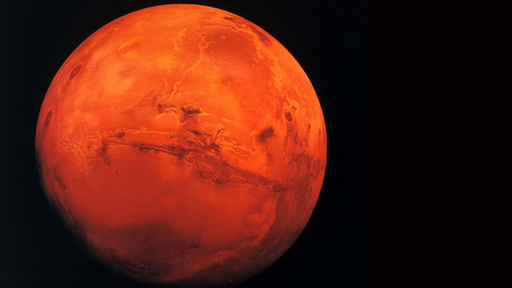 Der Mars leuchtend rot im All.
