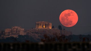 Ein roter Supermond geht hinter dem Parthenon auf der Akropolis auf