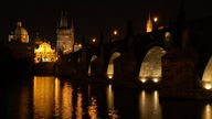 Das Foto zeigt eine Nachtaufnahme einer von unten angeleuchteten steinernen Brücke.