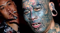 Tätowierter mit Gesichtstattoo und Gesichts- und Ohrenpiercings