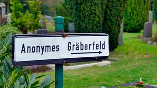 Hinweisschild zum anonymen Gräberfeld auf einem Friedhof