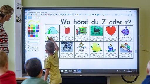 Grundschüler arbeiten an einer interaktiven digitalen Schultafel