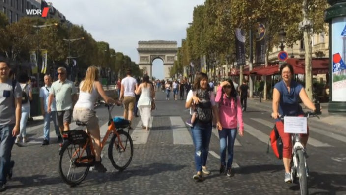 Fußgänger und Radfahrer auf den gesperrten Champs Elysées in Paris