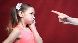 Symbolbild Schimpfen: Eine Hand mit ausgestrecktem Zeigefinger zeigt auf ein kleines Mädchen