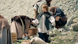 Fotos aus einem Fernsehfilm: ein Kind in Mittelalterkleidung steht in einem Steinbruch