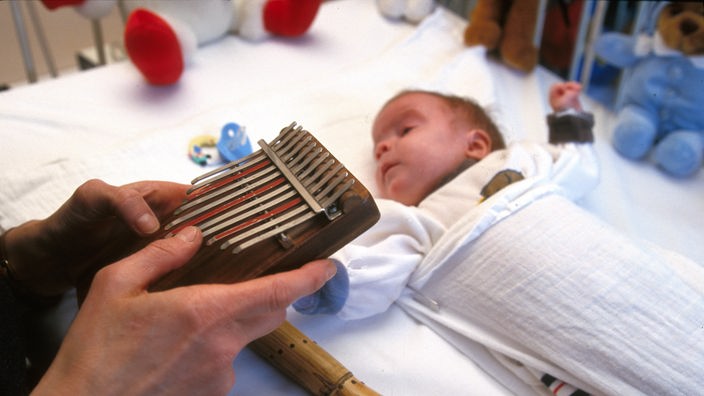 Jemand musiziert für ein Baby im Krankenhaus 