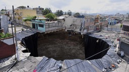 Luftaufnahme eines großen Loches in einem Wohngebiet in Guatemala. 