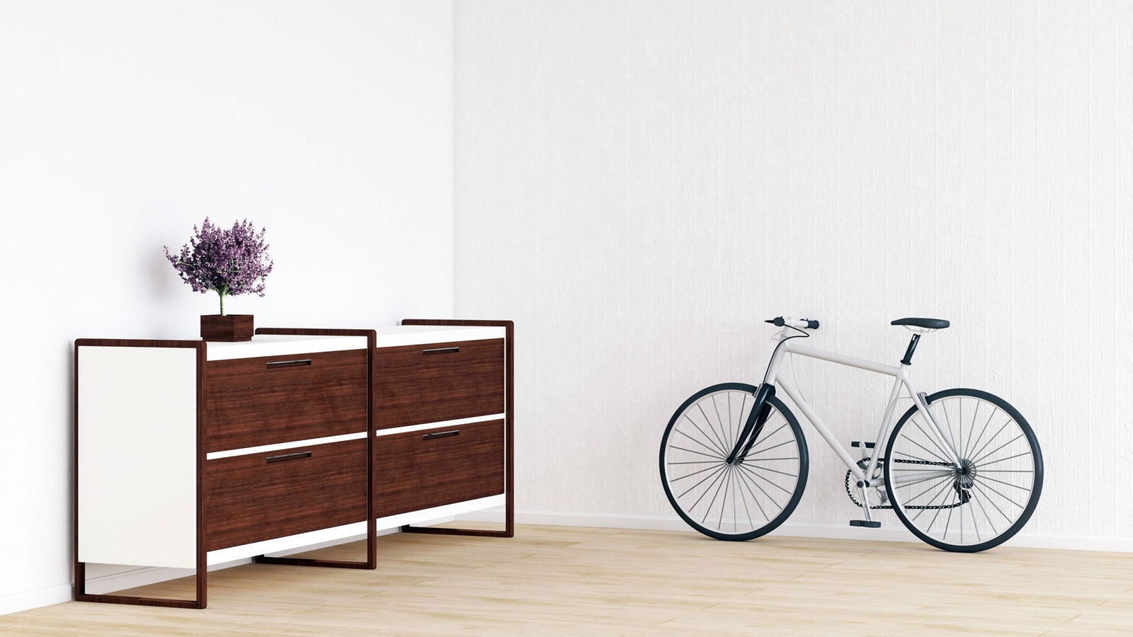 In einem Zimmer stehen nur eine Kommode mit Blumenvase und ein Fahrrad 