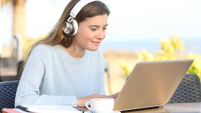 Eine junge Frau vor einem Computer im Freien