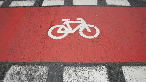 Fahrradpiktogramm auf rot gefärbtem Fahrradweg