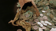 Münzen in einer zerbrochenn Vase aus Ton.