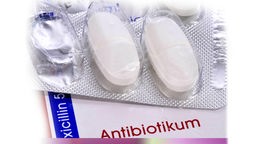 Antibiotika in Tablettenverpackung liegt auf der Schachtel mit Beschriftung.