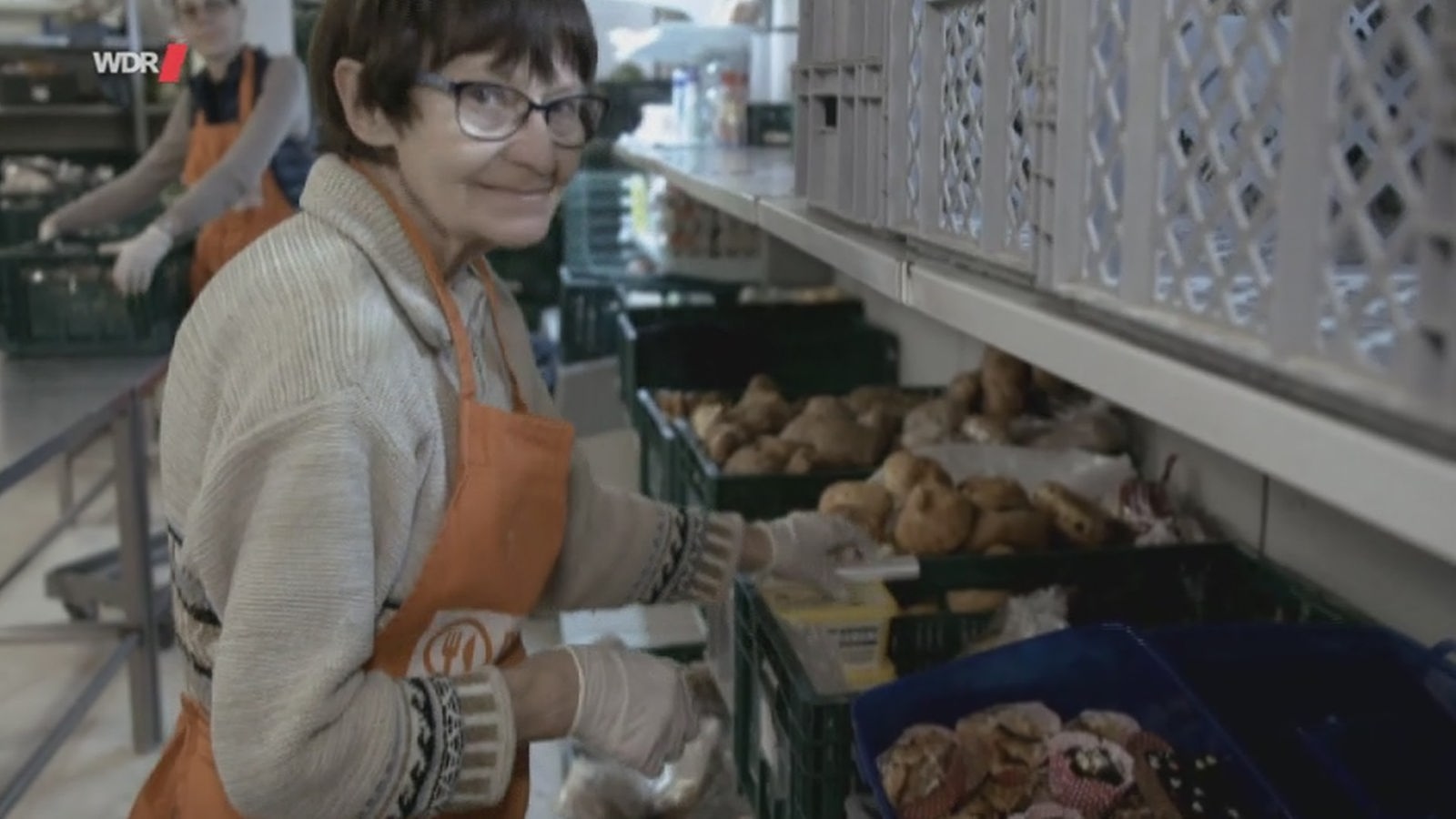 Eine Mitarbeiterin der Duisburger "Tafel" steht vor Körben von gespendetem Brot