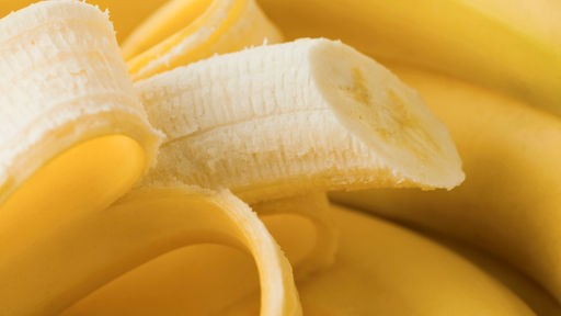 Frische Bananen, eine halb geschält