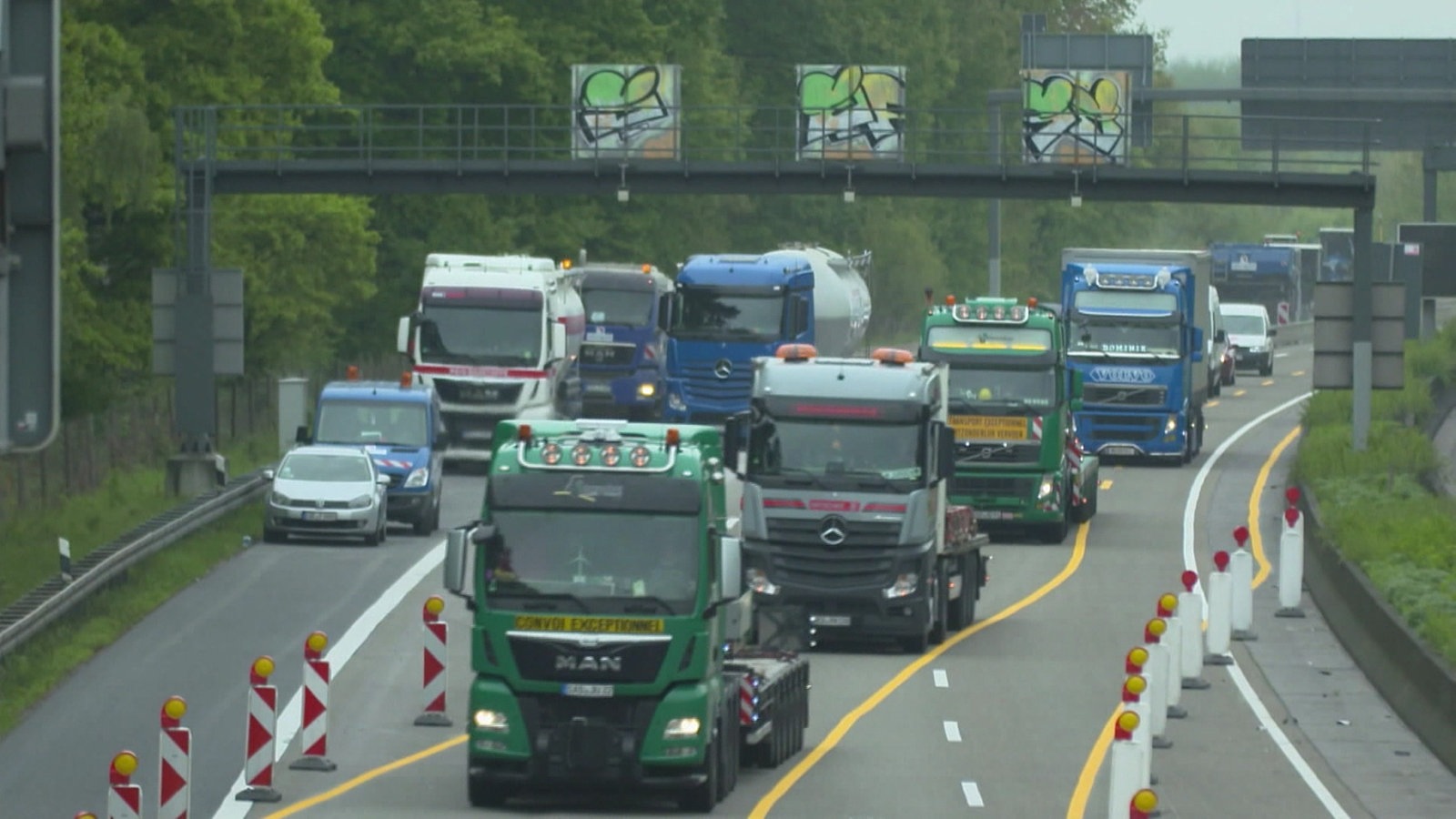 Lkws in einer Schlange auf der Autobahn bei einer Fahrbahnverengung aufgrund von Bauarbeiten.