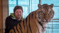 Prortrait von Remo Müller neben einem Tiger.