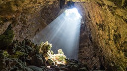 Licht fällt durch ein Loch in eine Höhle