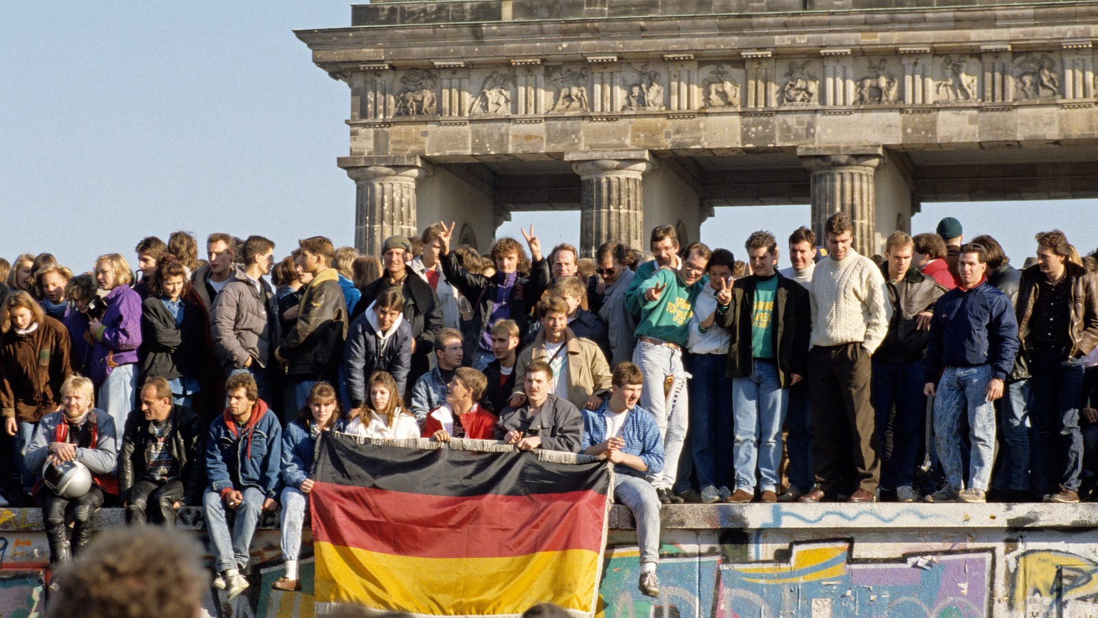 Menschen auf der Berliner Mauer direkt nach der Grenzöffnung