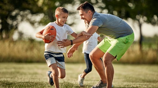Vater und Sohn spielen Rugby