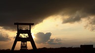 Zechenturm vor untergehender Sonne und dunklem Himmel 
