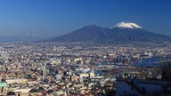 Im Vordergrund die Großstadt Neapel, im Hintergrund der schneebedeckte Vesuv
