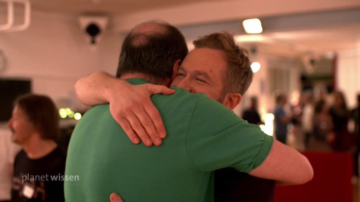Zwei Männer umarmen sich.