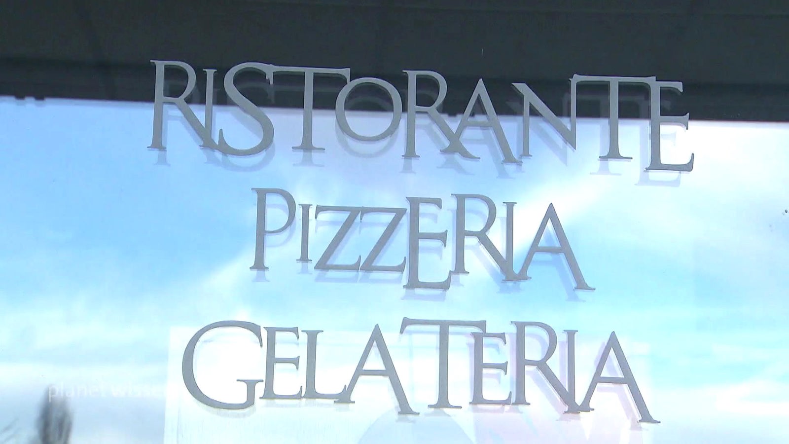 Fensterscheibe auf der der Schriftzug 'Ristorante Pizzeria Gelateria' angebracht ist.