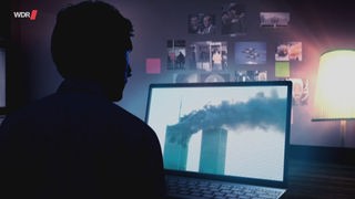 Die Silhouette eines Mannes, der vor einem Computerbildschirm sitzt