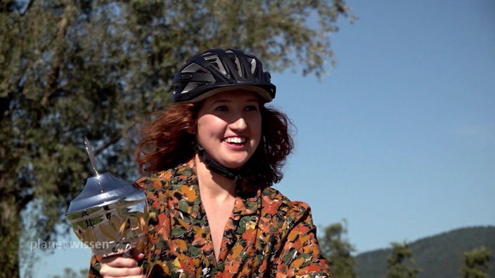 Frau mit Fahrradhelm und Pokal
