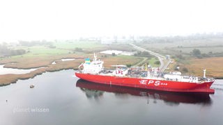 Ein großes Schiff mit der Aufschrift 'EPS Gas' liegt in einem Binnenhafen.